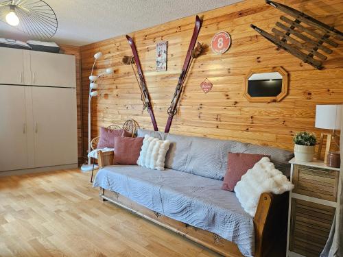 sala de estar con sofá y pared de madera en Aux pieds des pistes avec balcon - meublé 3 étoiles, en Orcières