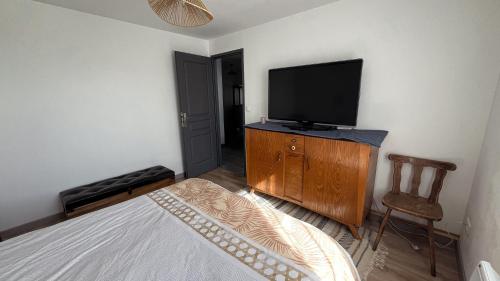 a bedroom with a bed and a flat screen tv at Maison Hémera, une pause en Auvergne in Lapeyrouse