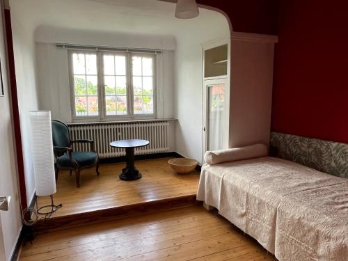 a bedroom with a bed and a table and a window at Haus Kroneck-Salis Ferienwohnung in Bad Iburg