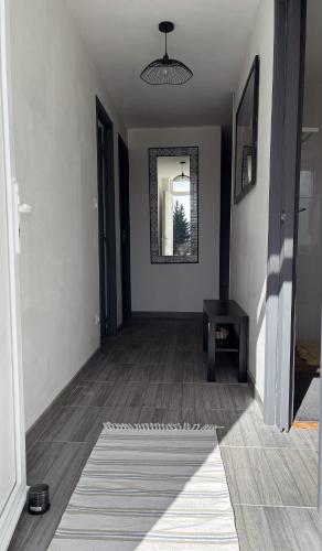 a hallway of a home with a mirror and a table at Maison Hémera, une pause en Auvergne in Lapeyrouse