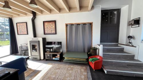 a living room with a staircase and a door at Maison Hémera, une pause en Auvergne in Lapeyrouse