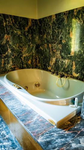 a bath tub in a bathroom with a black wall at Villa Trigatti Michieli 