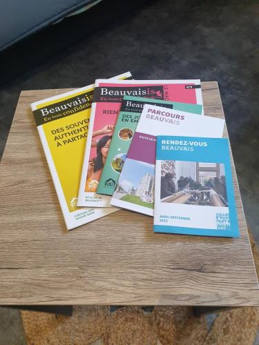 a pile of magazines sitting on a wooden table at Studio meublé en centre ville proche gare SNCF in Beauvais