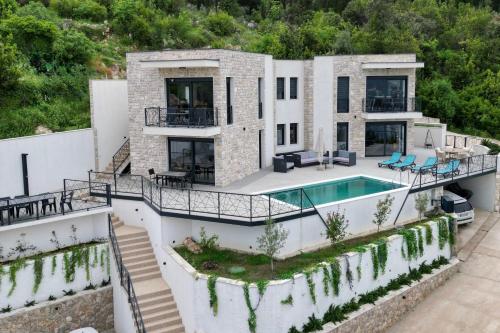 an aerial view of a house with a swimming pool at Bay View Village - Villa Eléanore 1 in MitroviÄ‡i