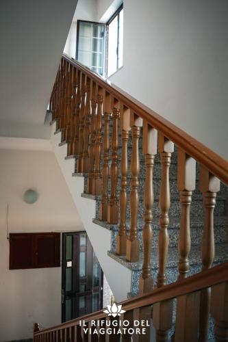 a staircase in a house with wooden railings at Il rifugio del viaggiatore in San Giorgio a Liri