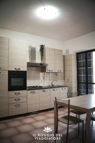 a kitchen with a wooden table and a dining room at Il rifugio del viaggiatore in San Giorgio a Liri