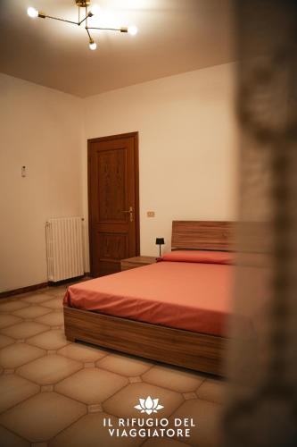a bedroom with a bed with a red bedspread at Il rifugio del viaggiatore in San Giorgio a Liri