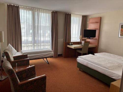 a hotel room with a bedroom with a bed and a desk at Hotel Flandrischer Hof in Cologne