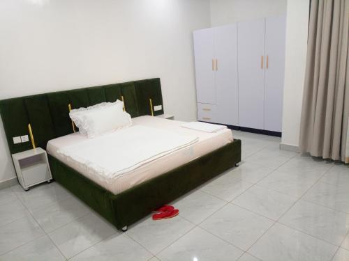 a bedroom with a bed with a green headboard at Kigali Nice Apartment in Kigali