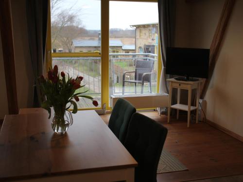 a room with a table with a vase of flowers on it at Pension Bäumi-Hof in Seehausen