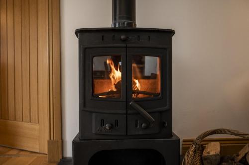 a black stove with a fire in a room at The Keep in Kirknewton