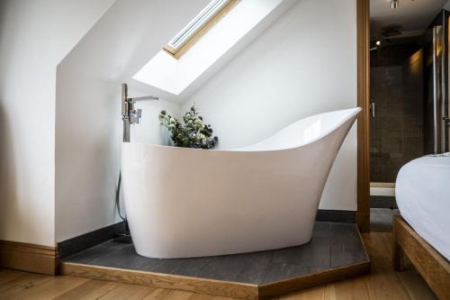 a bathtub in a bedroom with a skylight at The Keep in Kirknewton
