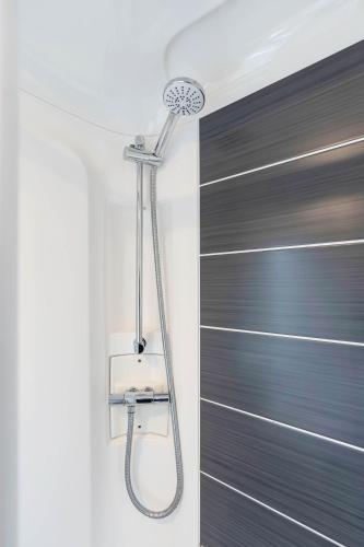a shower in a bathroom next to a door at Vacant Nests Roxburgh Court Seton Sands in Port Seton