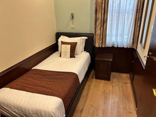 a small bedroom with a bed and a window at La Gaffe - Bed and Breakfast in London