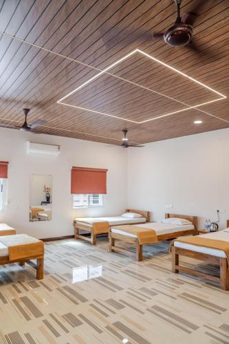a room with three beds and a wooden ceiling at The B Hive in Londa