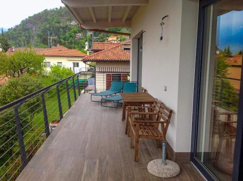 a balcony of a house with a table and chairs at Casa Robilio in Maccagno con Pino e Veddasca