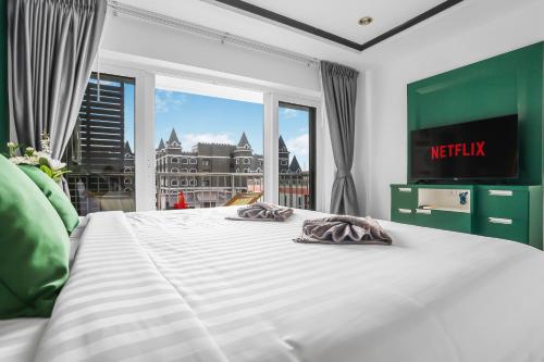 a large white bed in a room with a window at Luxurious Penthouse Pattaya in Pattaya South
