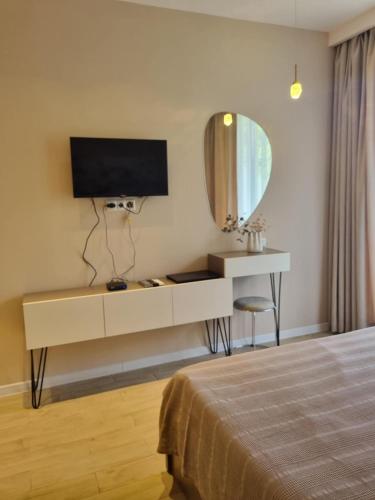 a bedroom with a white dresser with a tv and a mirror at Bamboo Beach Tsikhisdziri LATTE in Tsikhisdziri