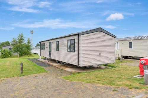 a small white trailer is parked in a yard at Vacant Nests Roxburgh Court Seton Sands in Port Seton