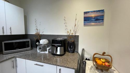 a kitchen with a counter with a microwave and a bowl of fruit at Armadale Country Retreat in Gqeberha
