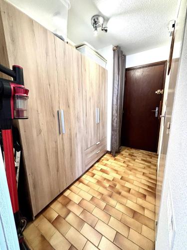 a hallway with wooden cabinets and a floor with a door at Appartment Cap d'Agde in Cap d'Agde
