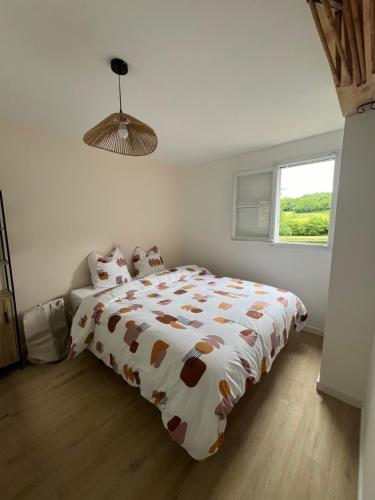 a bedroom with a bed with a brown and white comforter at L'etang calme in Manzat