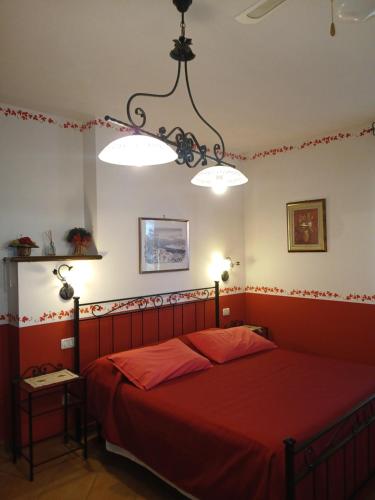 una camera con un letto rosso con due luci di Agriturismo Le Quattro Stagioni a Viterbo