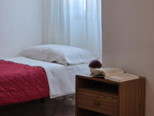 a bedroom with a bed and a table with a book at Teresa in Tortolì