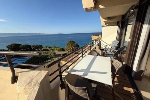 un balcon avec une table et des chaises et l'océan dans l'établissement Sea view apartment on the Ajaccio golf course, à Ajaccio