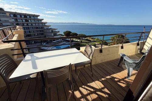 un balcon avec une table et des chaises et l'océan dans l'établissement Sea view apartment on the Ajaccio golf course, à Ajaccio