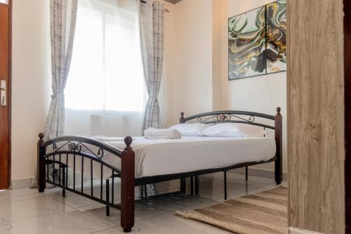 a bedroom with a bed and a window at Cosy 1 Bedroom in CBD Mombasa with City View in Mombasa