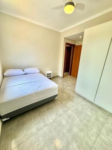 a bedroom with a bed and a ceiling fan at Apartamentos Belo Horizonte in Varginha