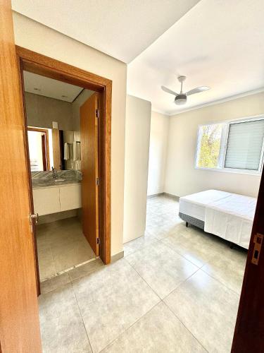 an empty room with a bed and a bathroom at Apartamentos Belo Horizonte in Varginha