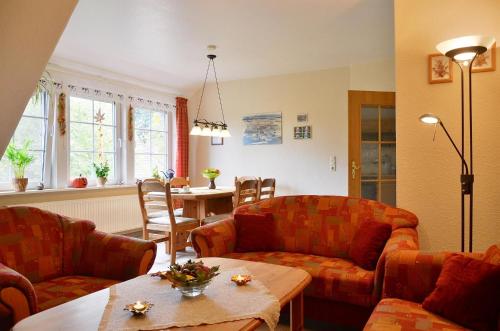 a living room with two couches and a table at Ferienwohnung Fegebank in Grethem