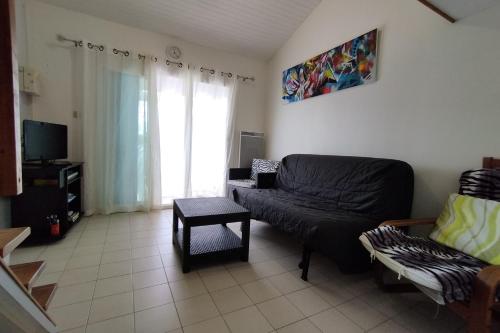 un salon avec un canapé et une chaise dans l'établissement Beach house, à Frontignan