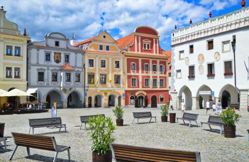 a group of buildings with benches in a courtyard at Penzion Krumlovské rozcestí in Český Krumlov