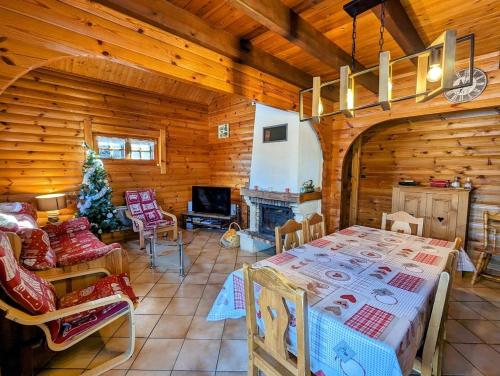 Cette cabane en rondins comprend une table et une cheminée. dans l'établissement Chalet scandinave excellente situation GERARDMER XONRUPT, à Xonrupt-Longemer