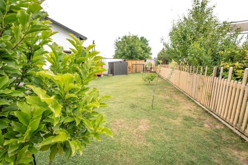 a yard with a fence and a small tree at Idyllisches, barrierefreies Ferienhaus in Furth