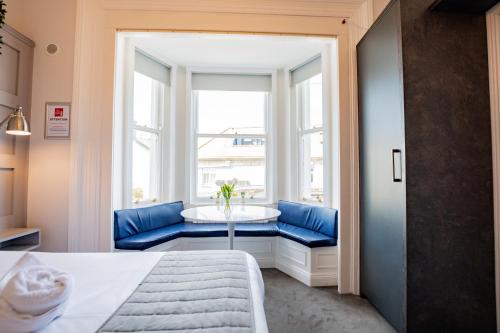 a bedroom with a blue couch and a tub in a window at Stylish Marina Escape in Dublin