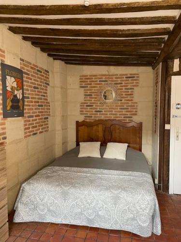 a bedroom with a bed in a brick wall at Appartement Des Lingots in Honfleur