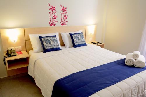 a bedroom with a large bed with blue and white sheets at Mandala Hotel in Encarnación