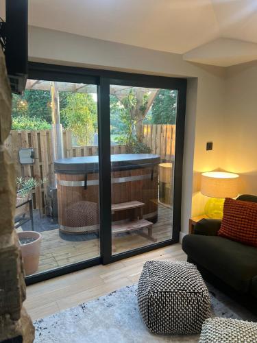 a room with a view of a tub through a sliding glass door at The Sanctuary Ashover in Chesterfield