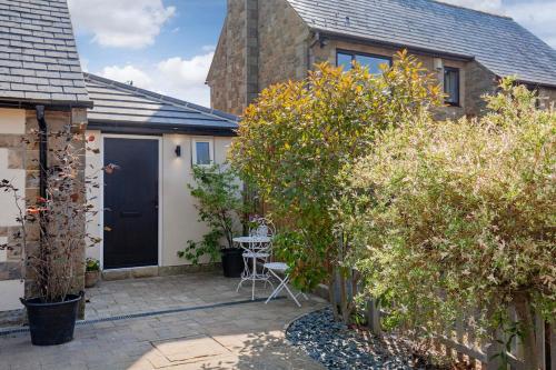 a patio with a black door and a table and chairs at The Sanctuary Ashover in Chesterfield
