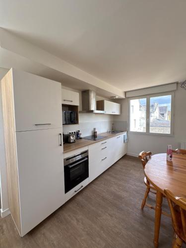 una cucina con un tavolo e un frigorifero bianco di Appartement Cosy et parking a Vannes