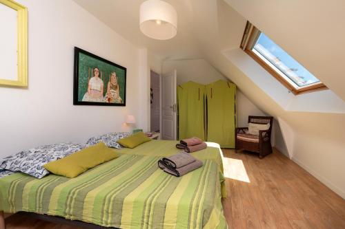 una camera da letto con letto verde in mansarda di Maison à 3min de la plage à pied a Sarzeau