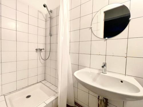 a white bathroom with a sink and a shower at Appartement T5 avec espace vert in Cauterets