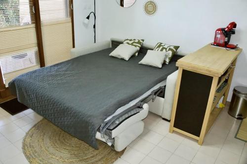 a large bed in a room with a table at Nice 27m with terrace and sea view in Rayol-Canadel-sur-Mer