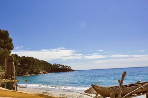 a beach with a boat sitting on the beach at Nice 27m with terrace and sea view in Rayol-Canadel-sur-Mer