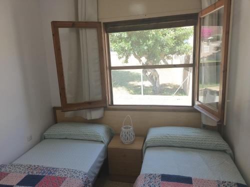 two beds in a small room with a window at Villa Angelita in Creixell