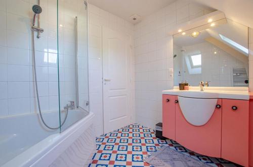 a bathroom with a red cabinet and a sink and a tub at Les lys in Saint-Julien-les-Villas